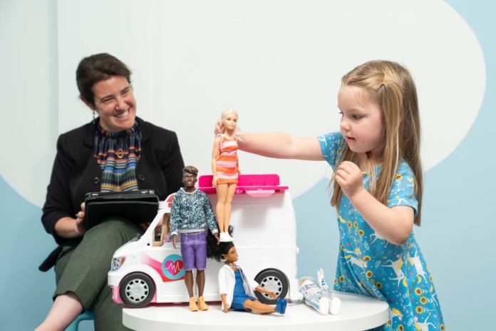 Девочка играет с куклой Барби