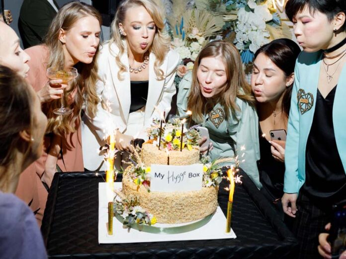 Девушки задувают свечи на торте