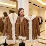 Спасаемся от морозов Девушка выбирает дубленку в магазине